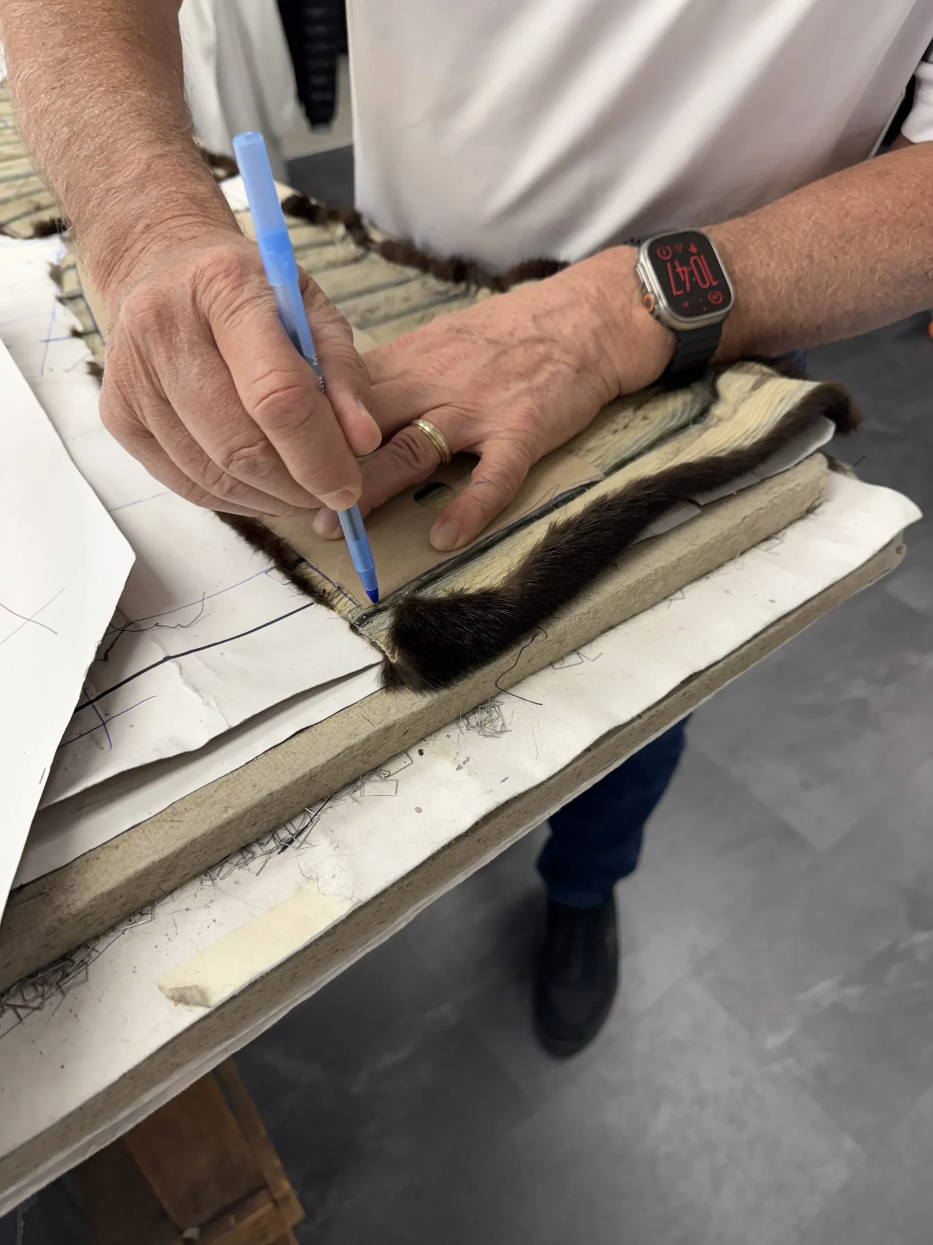 Samuel Manteaux artisan tracing a pattern on fur